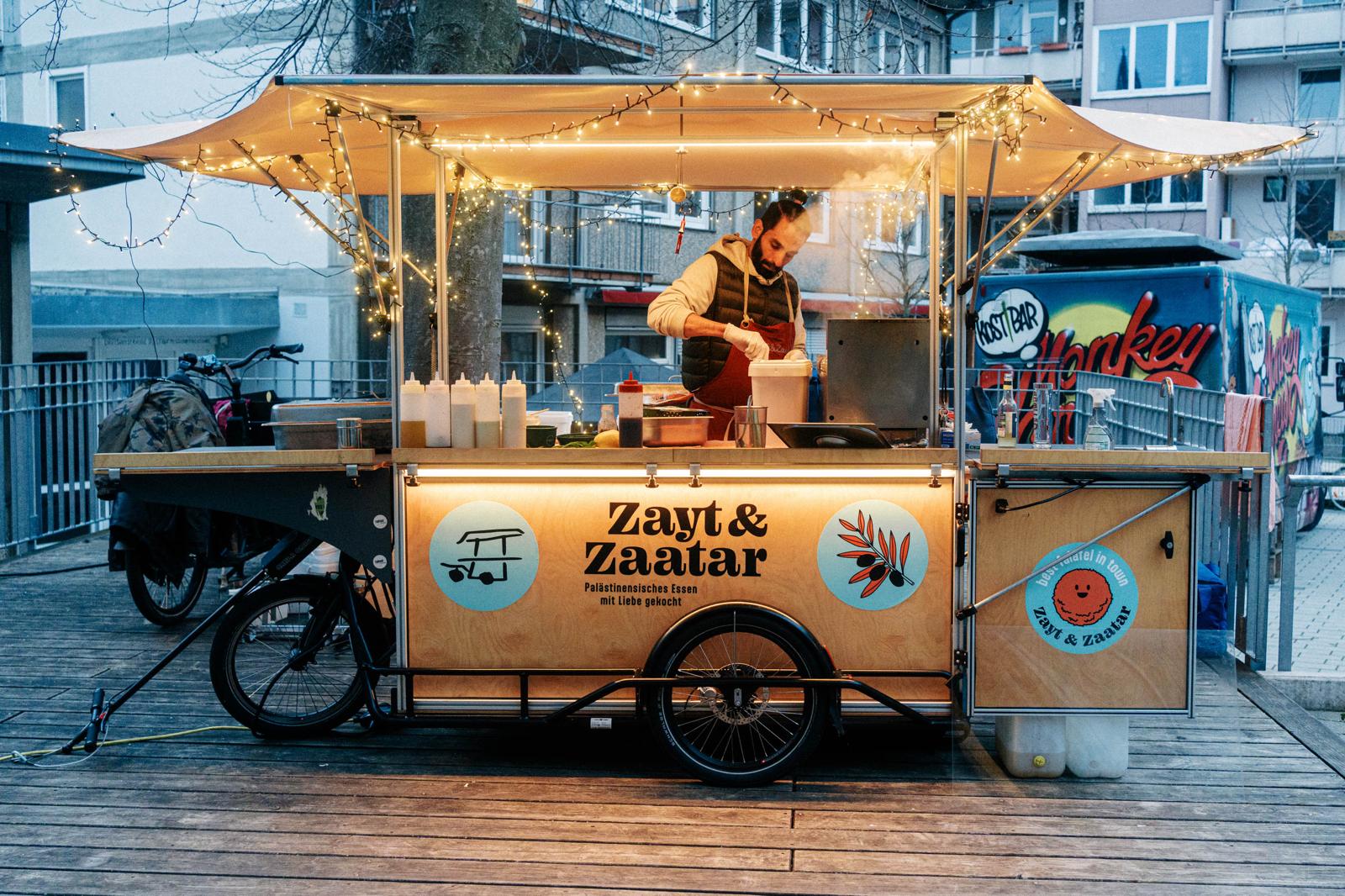 Abendliches Streetfood-Festival: Menschen stehen an einer mobilen Küche auf Basis eines CARLA Lastenrad-Anhängers an